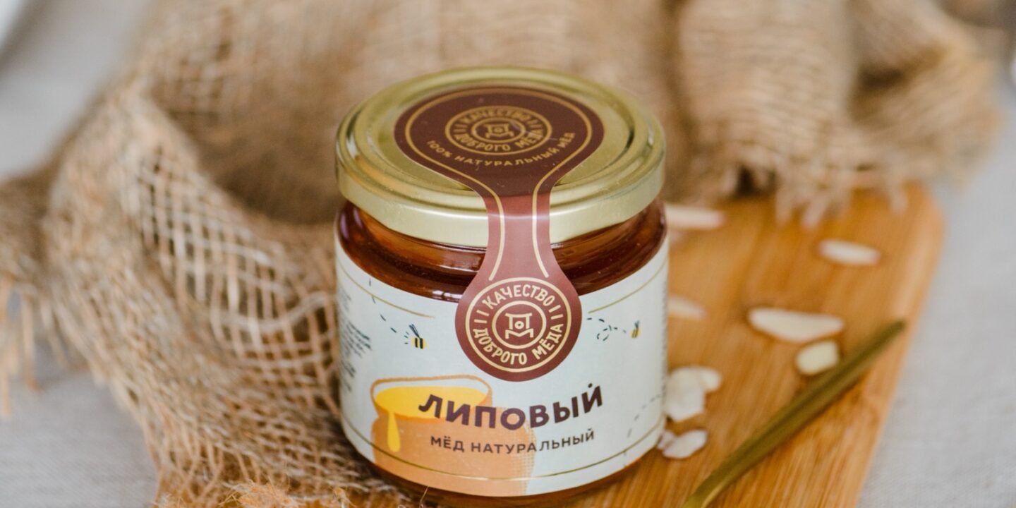 Банка натурального липового мёда на деревянной доске
