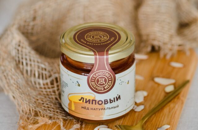 Банка натурального липового мёда на деревянной доске